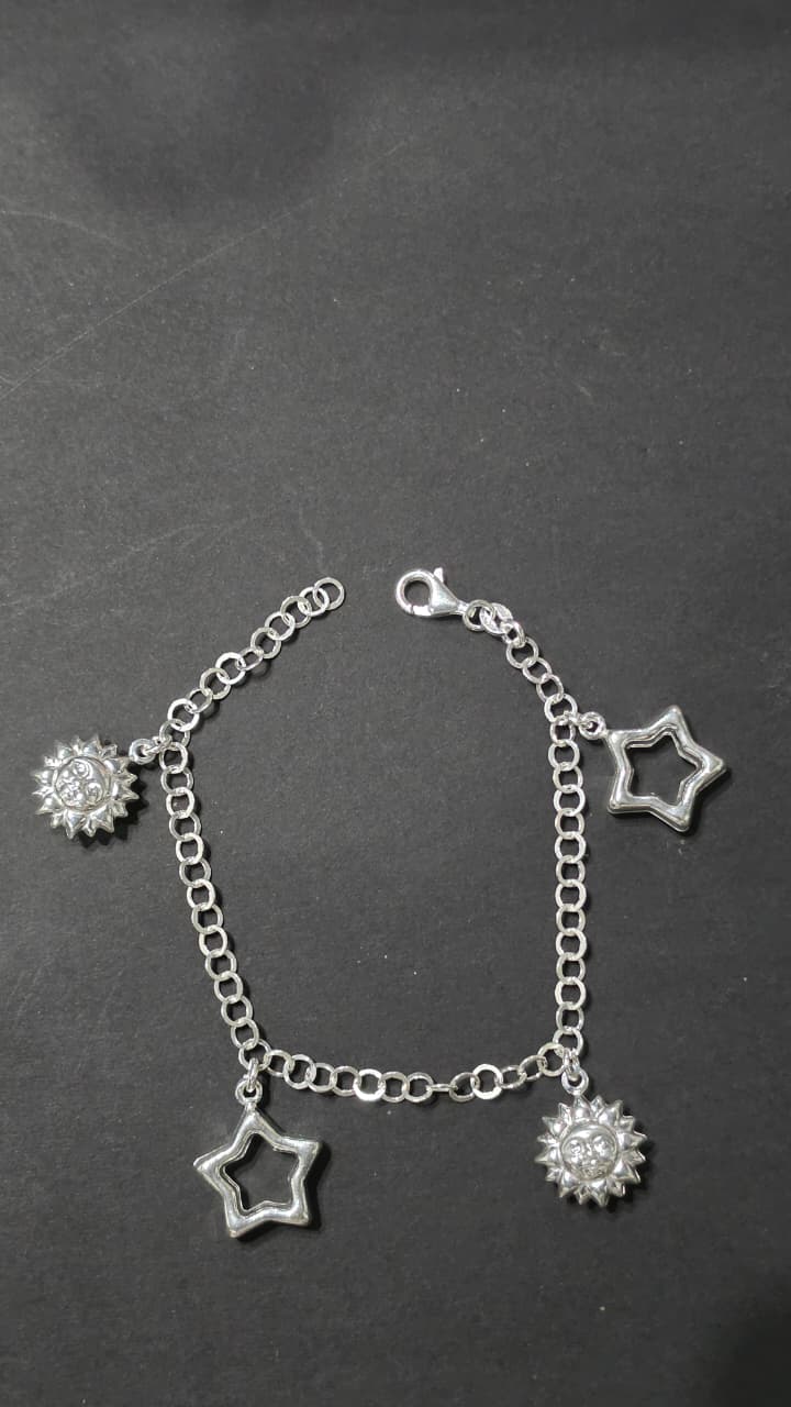 Brazalete de plata con dijes de estrellas y soles
